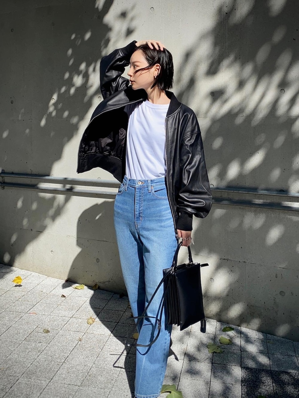 ブラック系のMA-1、ブルー系のデニムパンツを着用したレディースの秋コーディネートの4枚目の写真