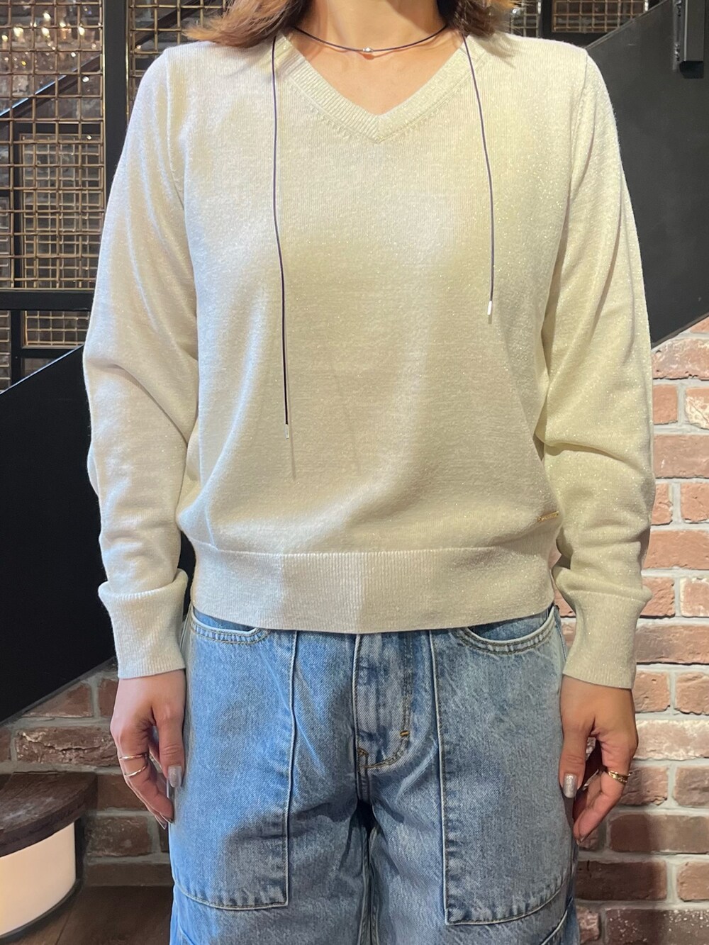 ホワイト系のMA-1、ホワイト系のニット/セーター、ブラック系のネックレスを着用したレディースの秋コーディネートの3枚目の写真