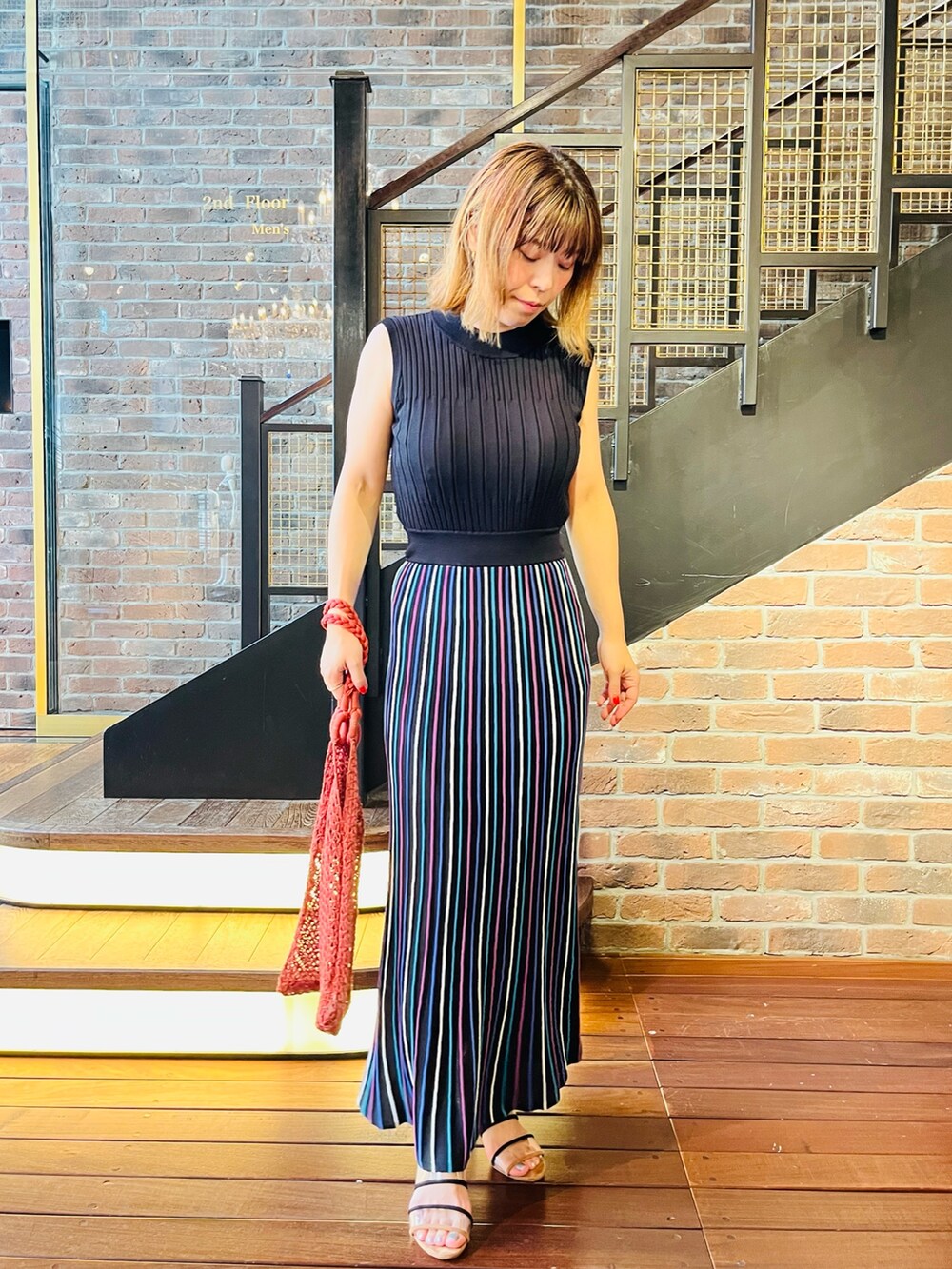 ブルー系のワンピース、ホワイト系のカーディガン/ボレロ、レッド系のトートバッグを着用したレディースの夏コーディネートの2枚目の写真