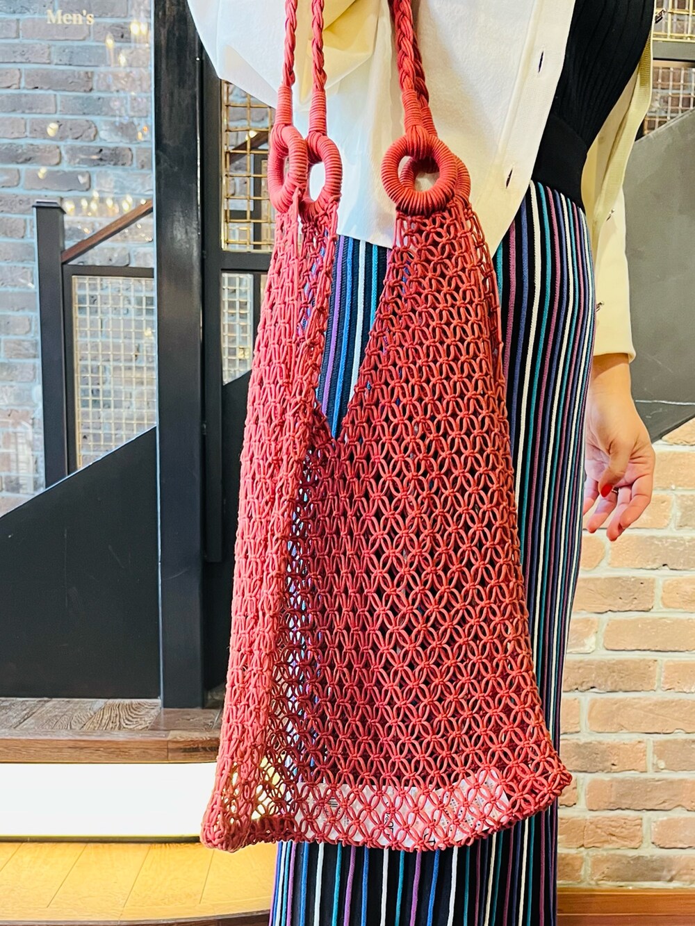 ブルー系のワンピース、ホワイト系のカーディガン/ボレロ、レッド系のトートバッグを着用したレディースの夏コーディネートの4枚目の写真