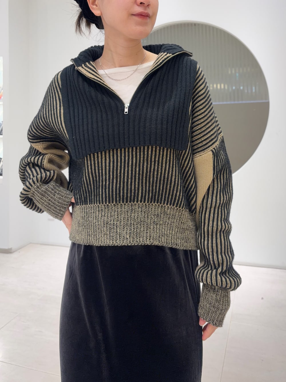 ブラック系のニット/セーター、グレー系のスカートを着用したレディースの冬コーディネートの3枚目の写真