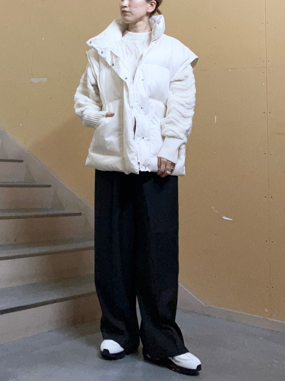 イエロー系のスニーカー、グレー系のその他パンツ、ホワイト系のダウンジャケット/コートを着用したレディースの秋コーディネートの2枚目の写真