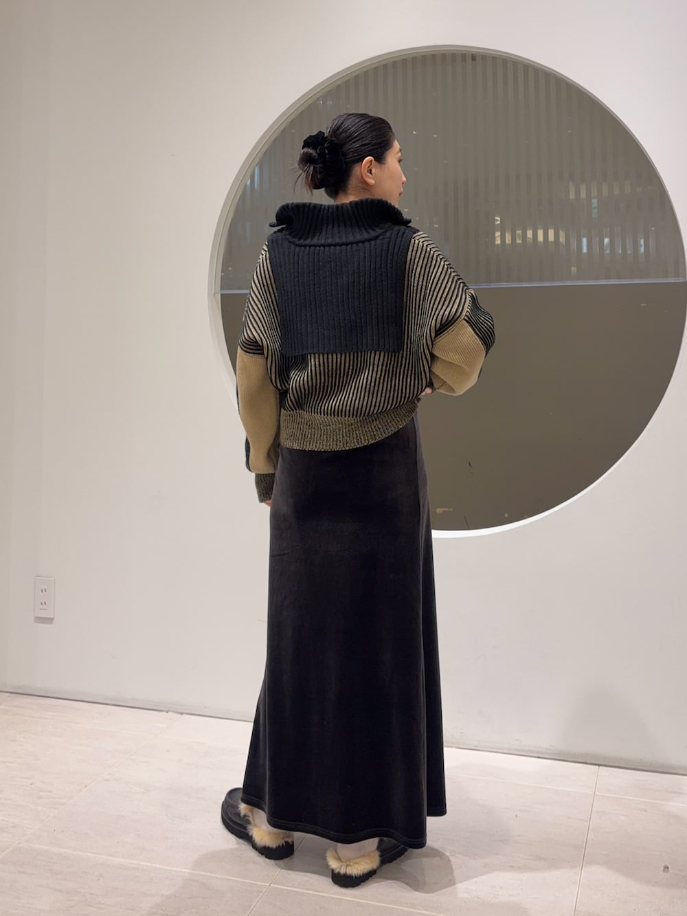 ブラック系のニット/セーター、グレー系のスカートを着用したレディースの冬コーディネートの2枚目の写真