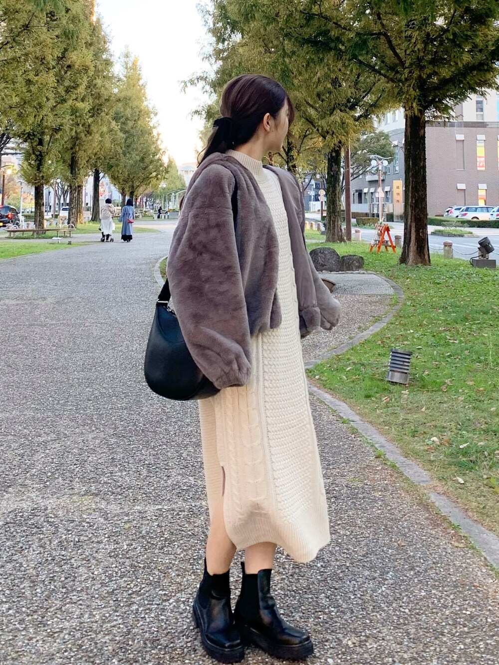 ベージュ系のブルゾン、ホワイト系のワンピース、ブラック系のバッグを着用したレディースの秋コーディネートの2枚目の写真