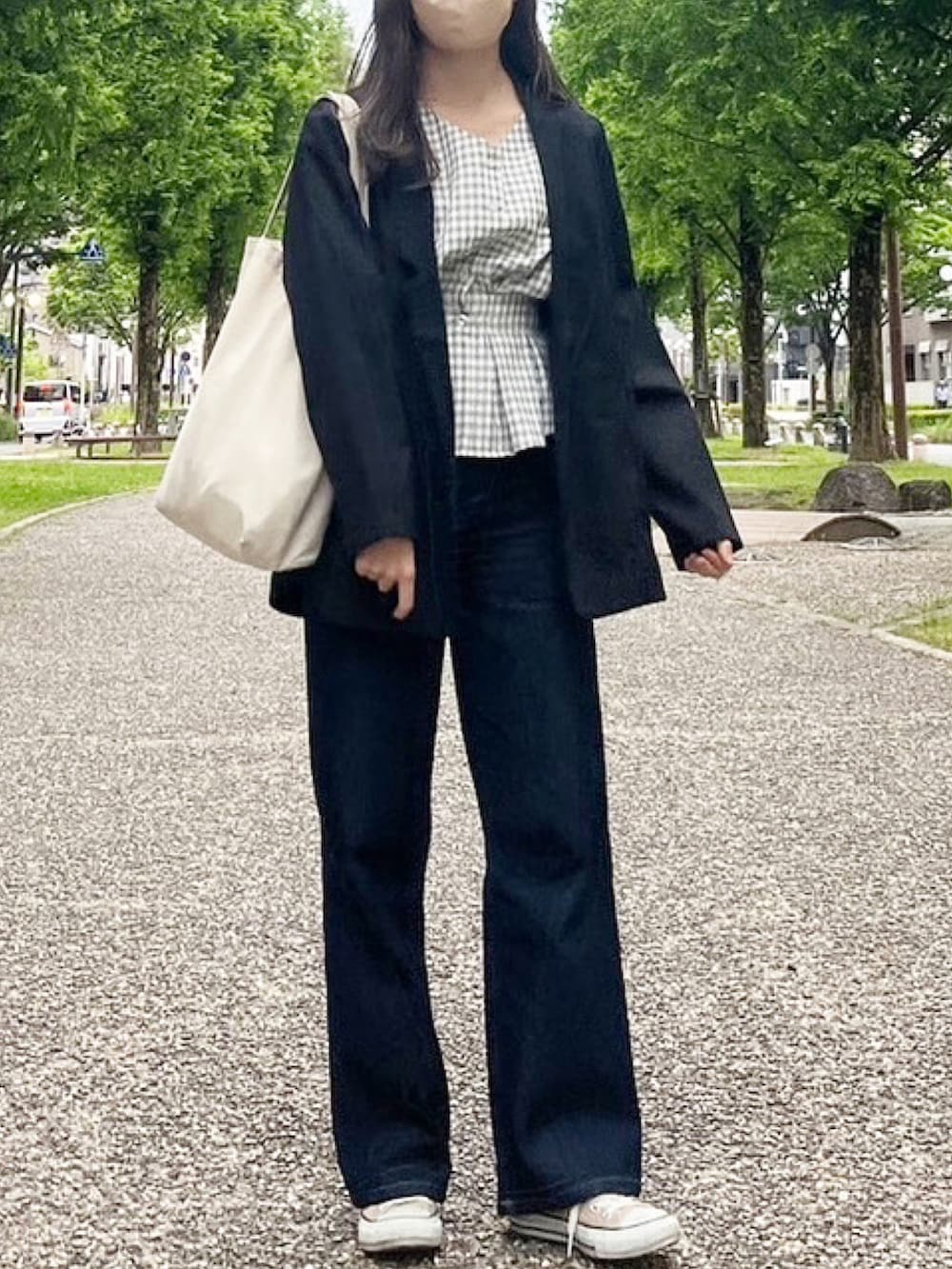 ブラック系のテーラードジャケット、ベージュ系のスニーカーを着用したレディースの春コーディネートの2枚目の写真