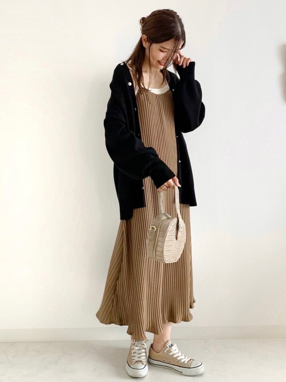 ベージュ系のワンピース、ホワイト系のカーディガン/ボレロ、ベージュ系のショルダーバッグを着用したレディースの秋コーディネートの2枚目の写真