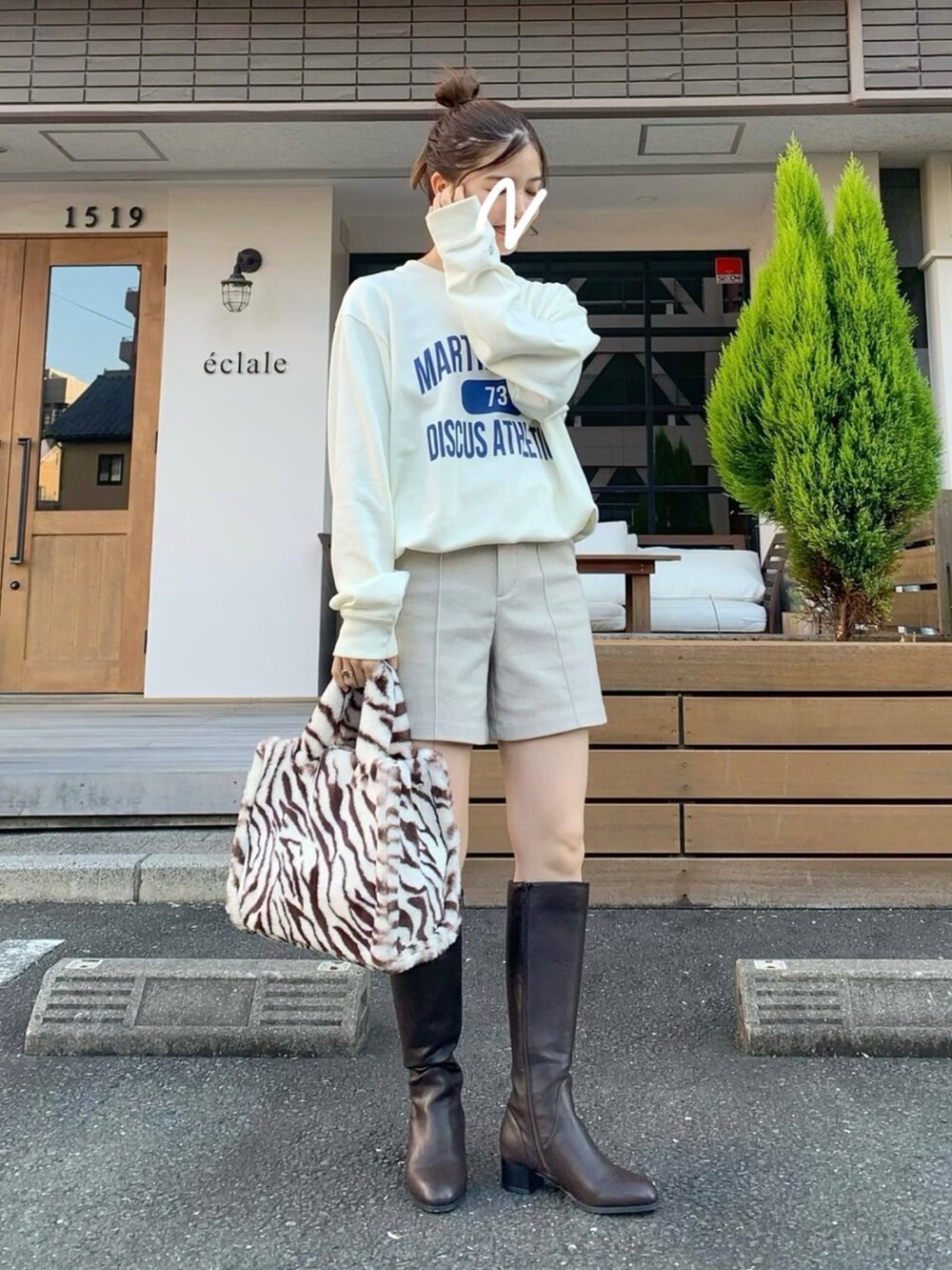 ホワイト系のスウェット、ホワイト系のパンツ、ブラウン系のバッグを着用したレディースの秋コーディネートの3枚目の写真