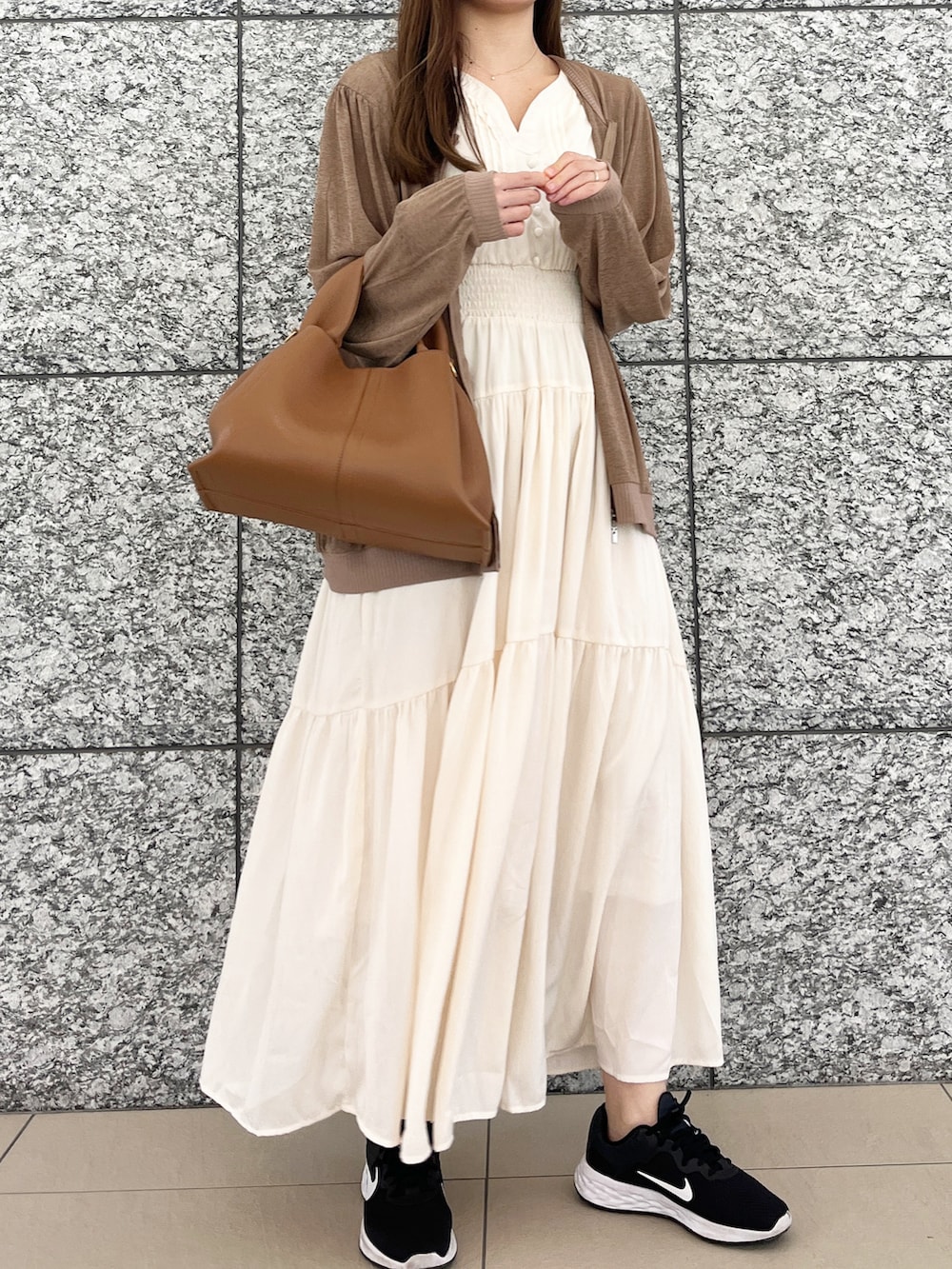 ベージュ系のブルゾン、ホワイト系のワンピース/ドレス、ブラック系のスニーカーを着用したレディースの春コーディネートの2枚目の写真