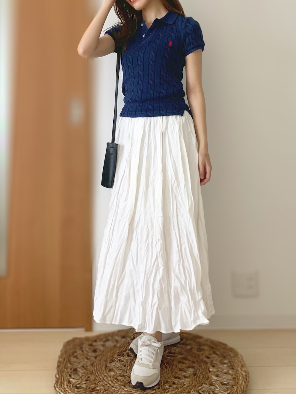 ブルー系のポロシャツ、ホワイト系のスカート、ベージュ系のスニーカーを着用したレディースの夏コーディネートの2枚目の写真