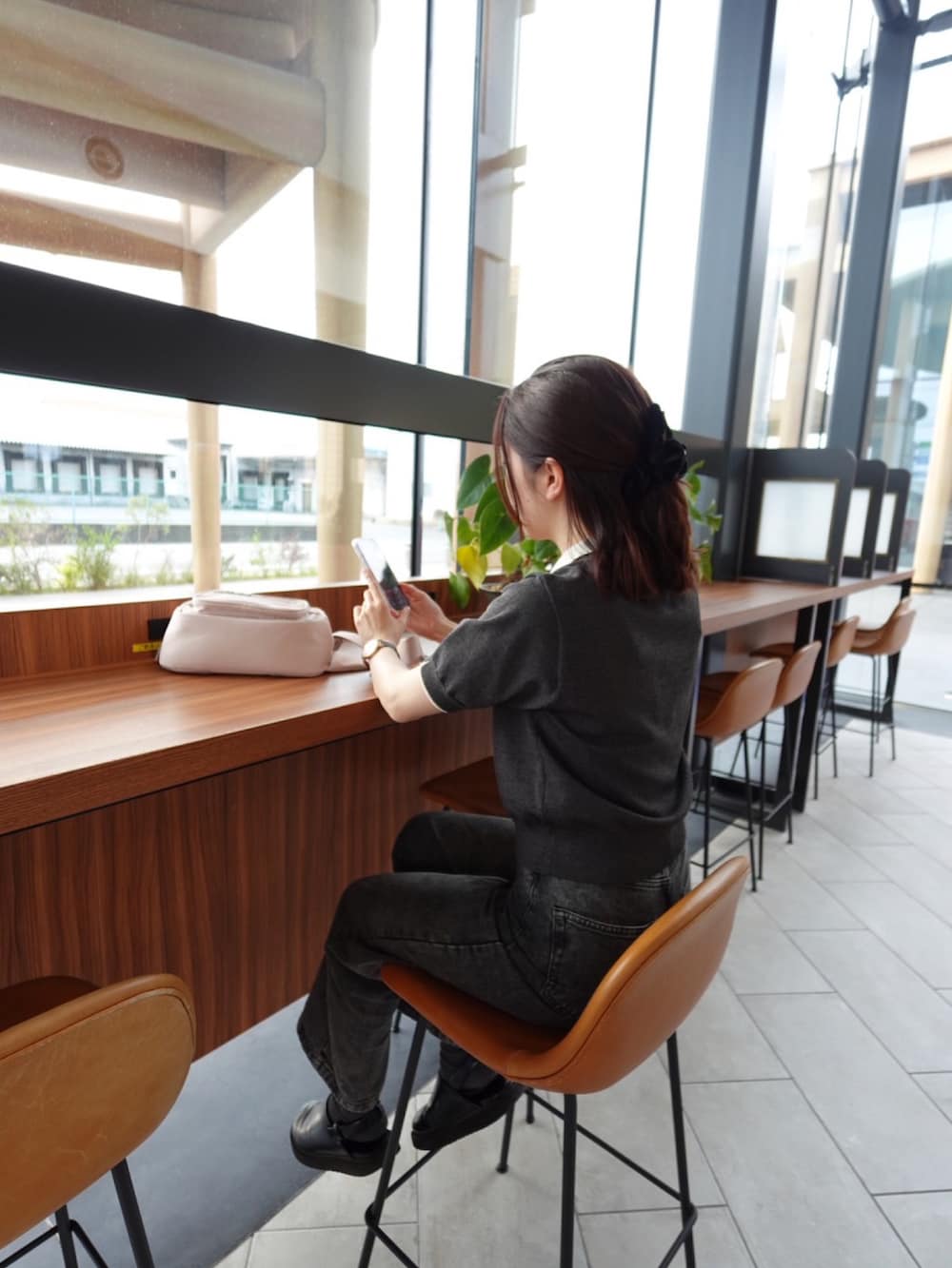 グレー系のニット/セーター、ブラック系のカーゴパンツ、ゴールド系のアナログ腕時計を着用したレディースの夏コーディネートの2枚目の写真