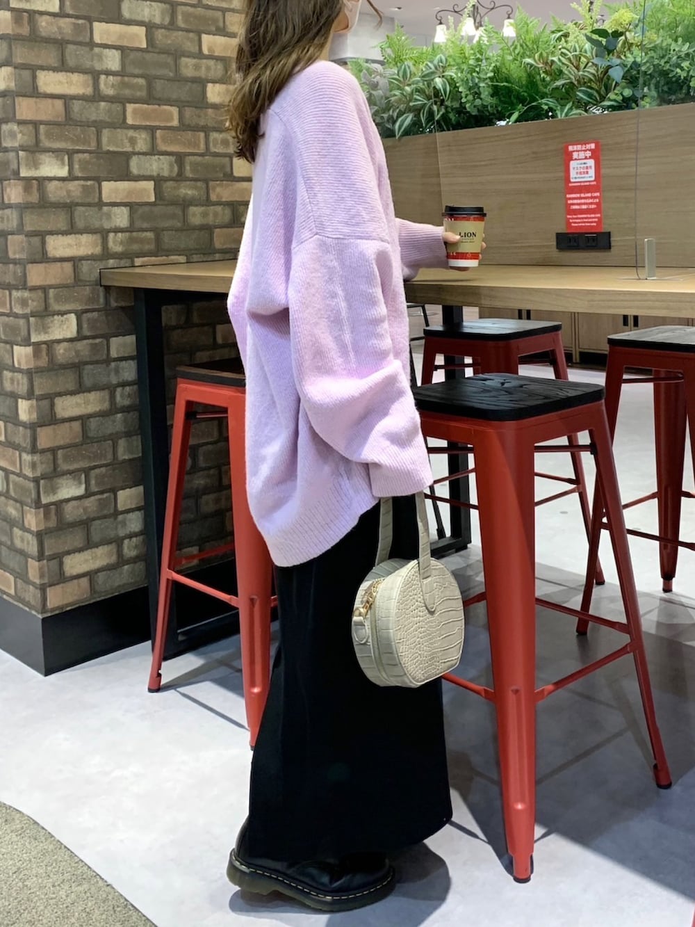 パープル系のカーディガン/ボレロ、ブラック系のワンピース、ベージュ系のショルダーバッグを着用したレディースの冬コーディネートの2枚目の写真