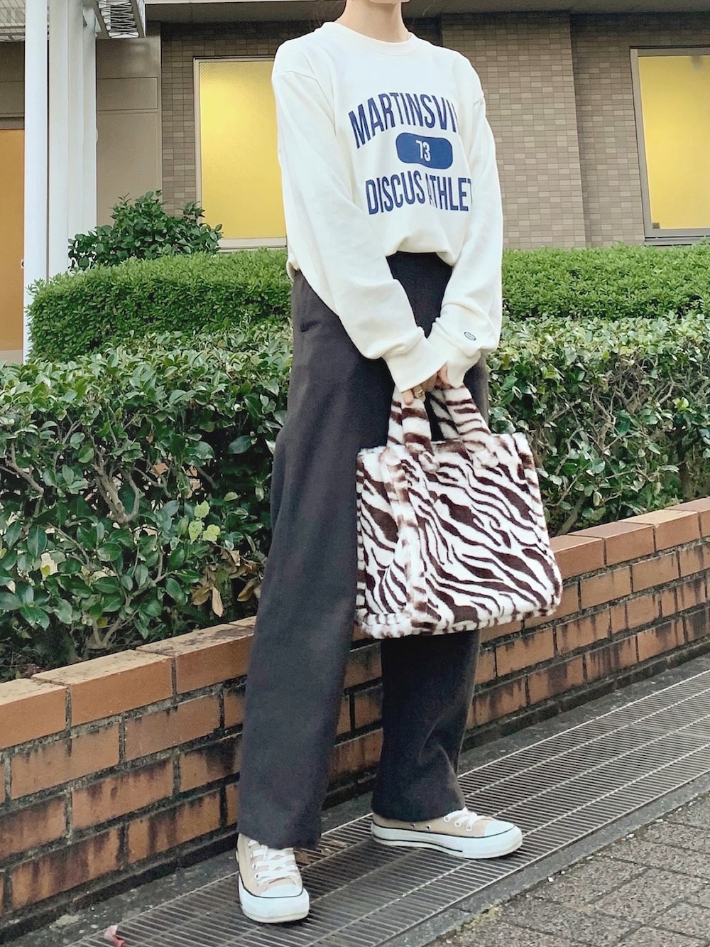 ホワイト系のスウェット、ブラウン系のパンツ、ブラウン系のバッグを着用したレディースの秋コーディネートの3枚目の写真
