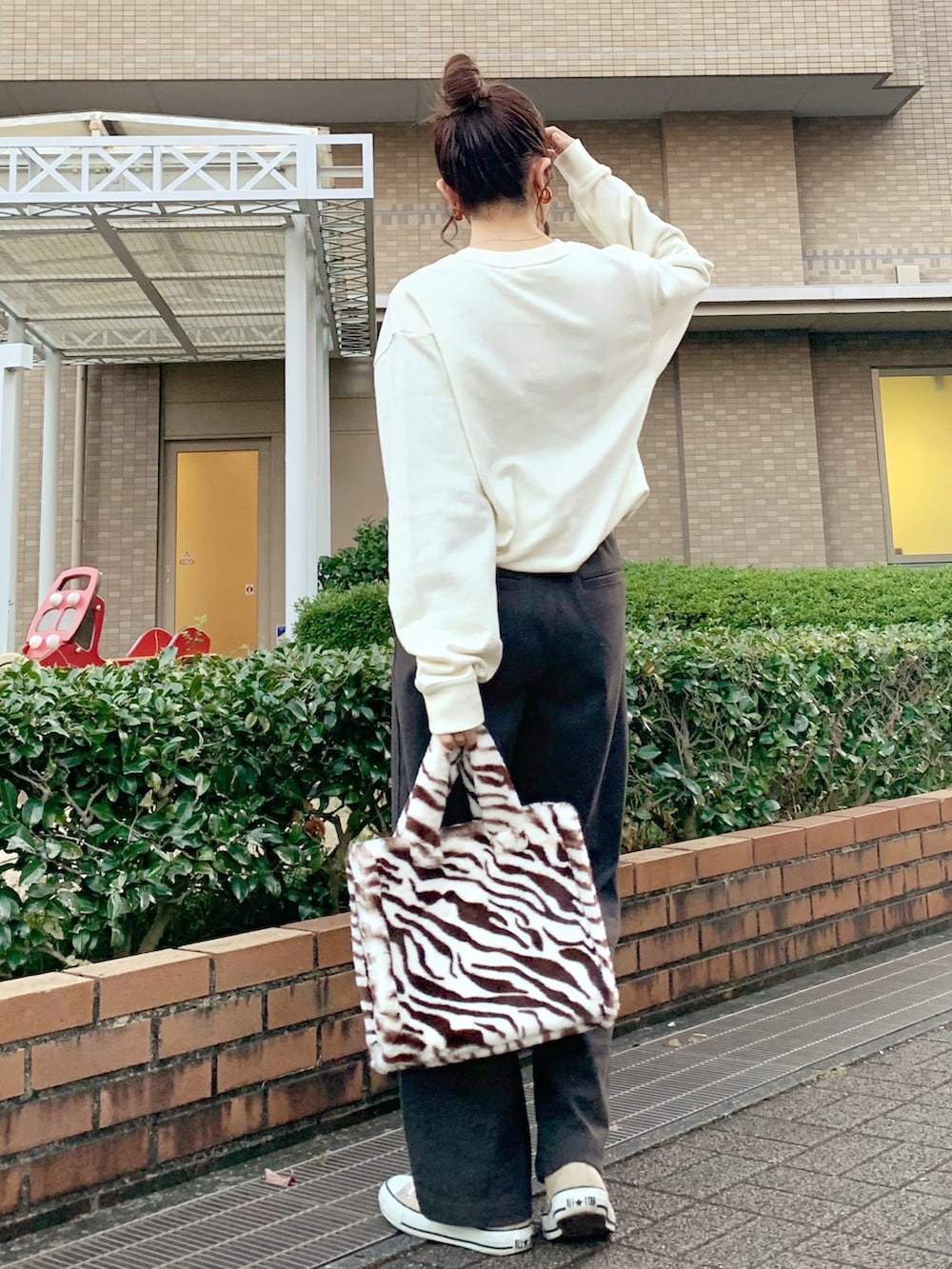 ホワイト系のスウェット、ブラウン系のパンツ、ブラウン系のバッグを着用したレディースの秋コーディネートの2枚目の写真