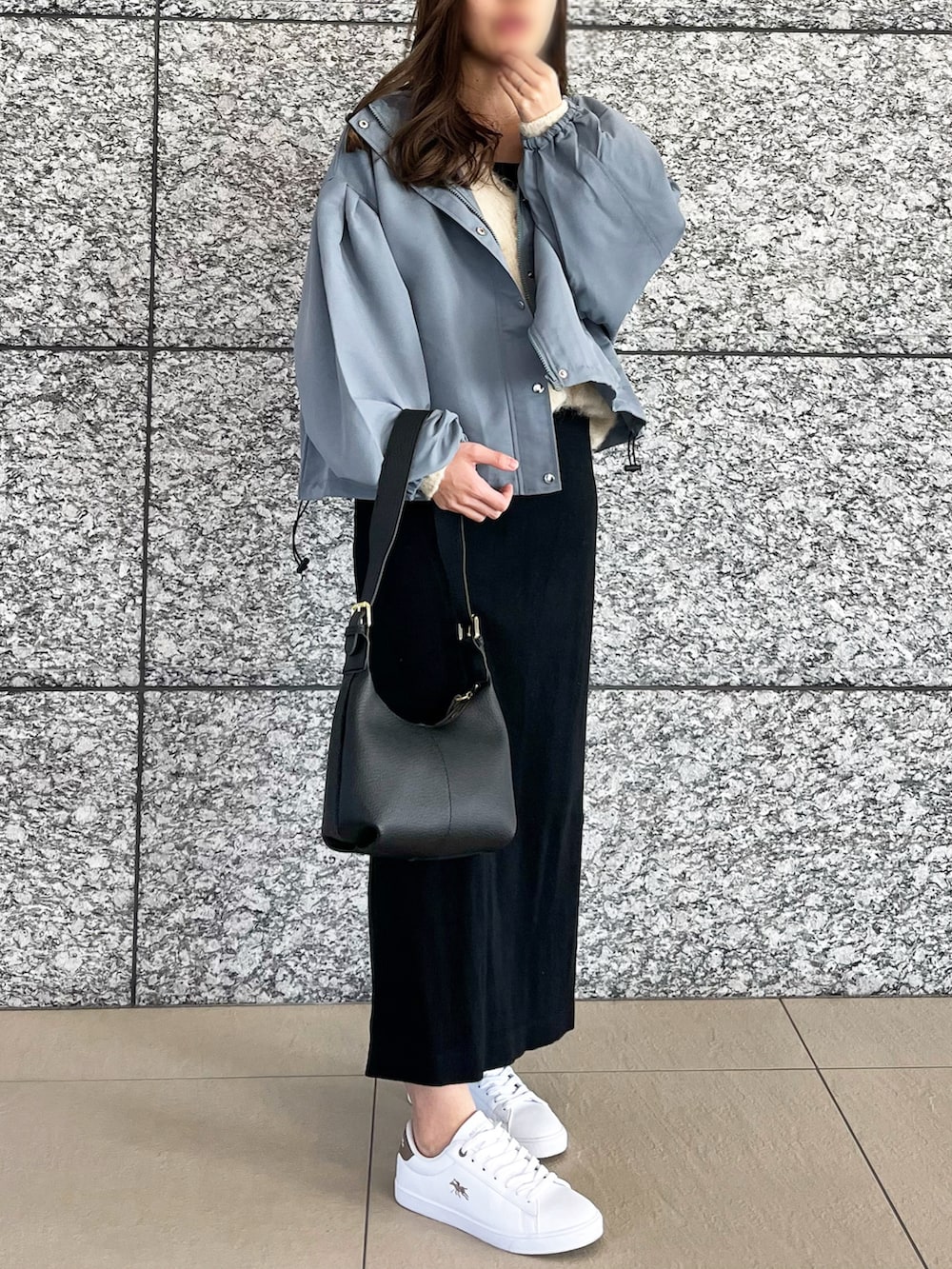 ブルー系のマウンテンパーカー、ブラック系のショルダーバッグ、ベージュ系のスニーカーを着用したレディースの春コーディネートの2枚目の写真