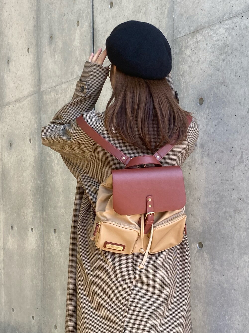 ブラウン系のバックパック/リュック、ブラウン系のジャケット/アウター、ブラック系のニット/セーターを着用したレディースの秋コーディネートの2枚目の写真