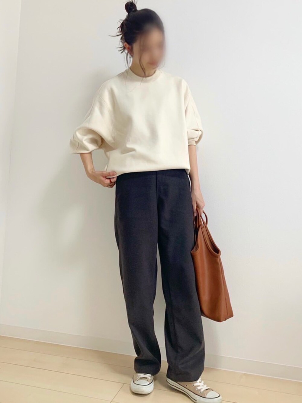 ホワイト系のスウェット、ブラウン系のパンツ、ブラウン系のトートバッグを着用したレディースの秋コーディネートの2枚目の写真