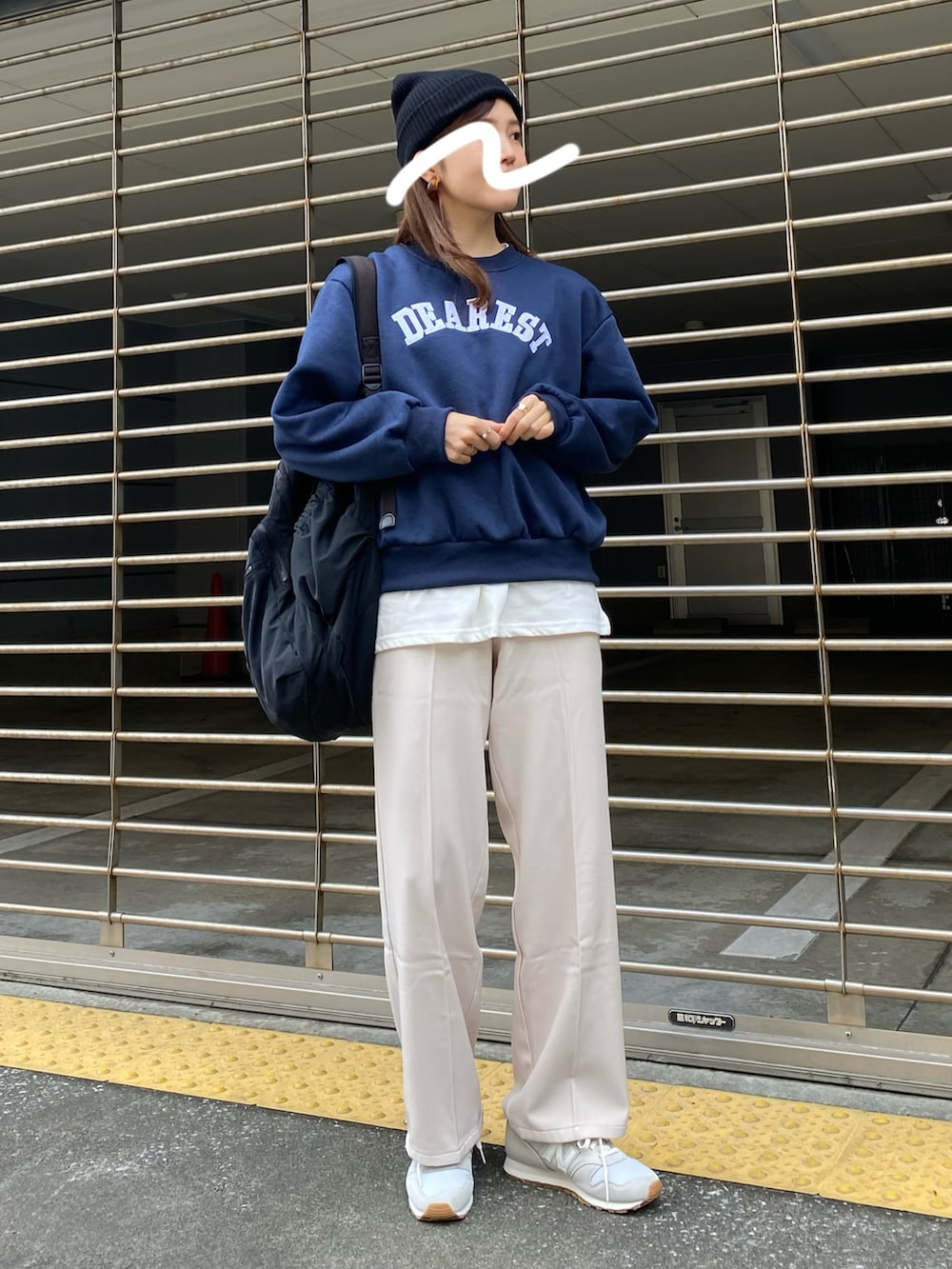 ブルー系のスウェット、ベージュ系のパンツ、グレー系のスニーカーを着用したレディースの秋コーディネートの2枚目の写真