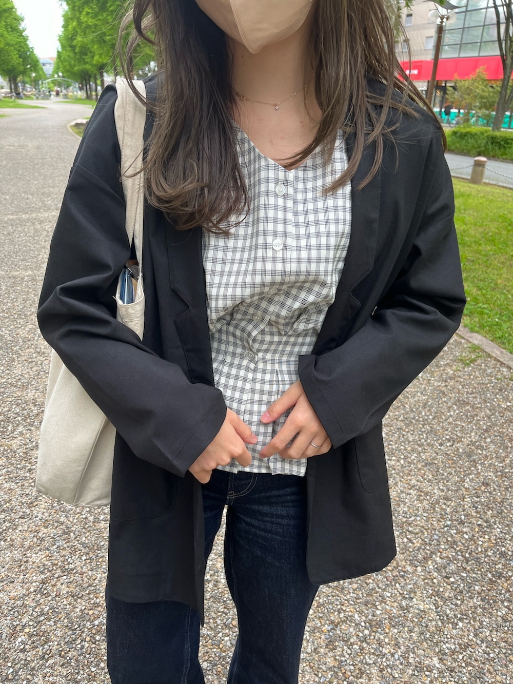 ブラック系のテーラードジャケット、ベージュ系のスニーカーを着用したレディースの春コーディネートの3枚目の写真