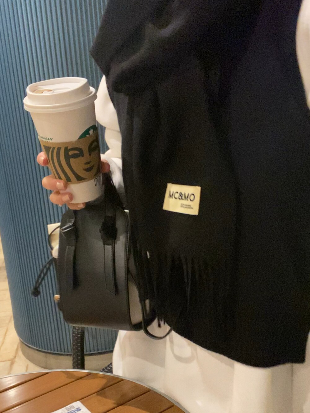 ブラック系のショルダーバッグ、ホワイト系のスウェット、ホワイト系のシャツワンピースを着用したレディースの冬コーディネートの2枚目の写真