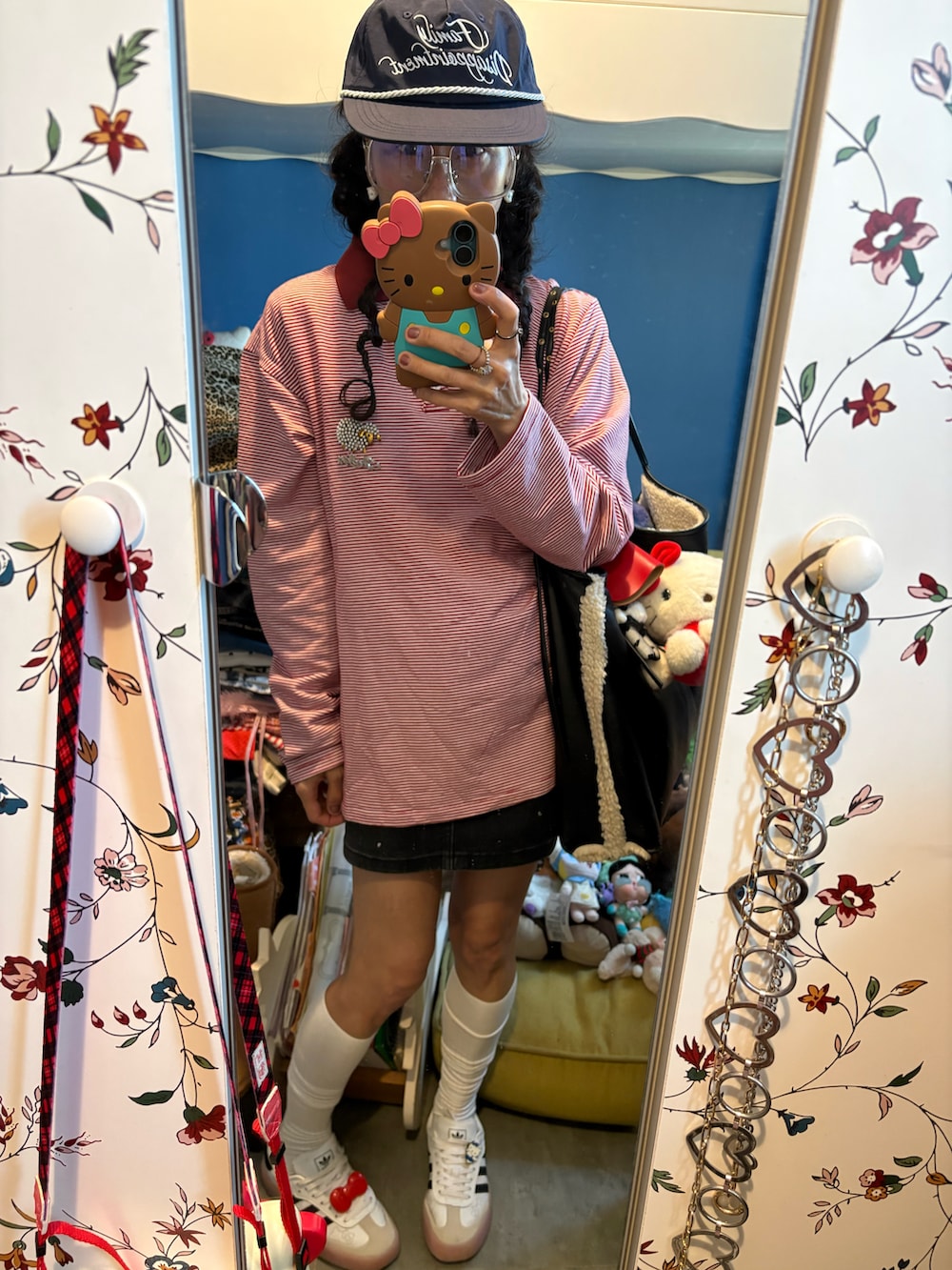 レッド系のポロシャツ、ブラック系のデニムスカート、ホワイト系のハンドバッグを着用したレディースの冬コーディネートの2枚目の写真