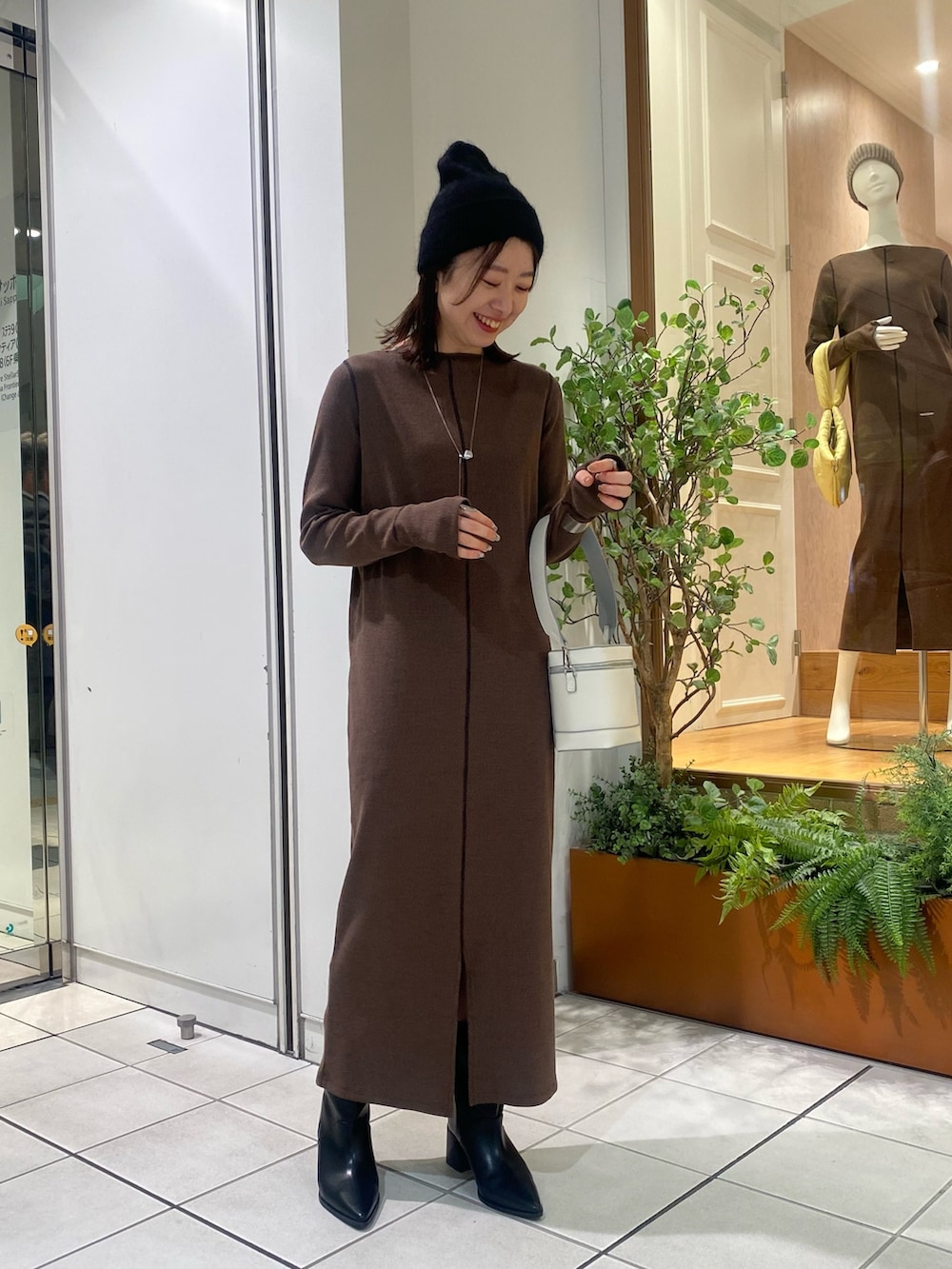 ブラウン系のワンピース、ブラック系のハットを着用したレディースの秋コーディネートの2枚目の写真