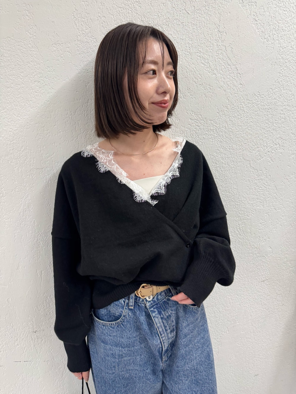 ブラック系のニット/セーター、ブルー系のデニムパンツを着用したレディースの秋コーディネートの4枚目の写真