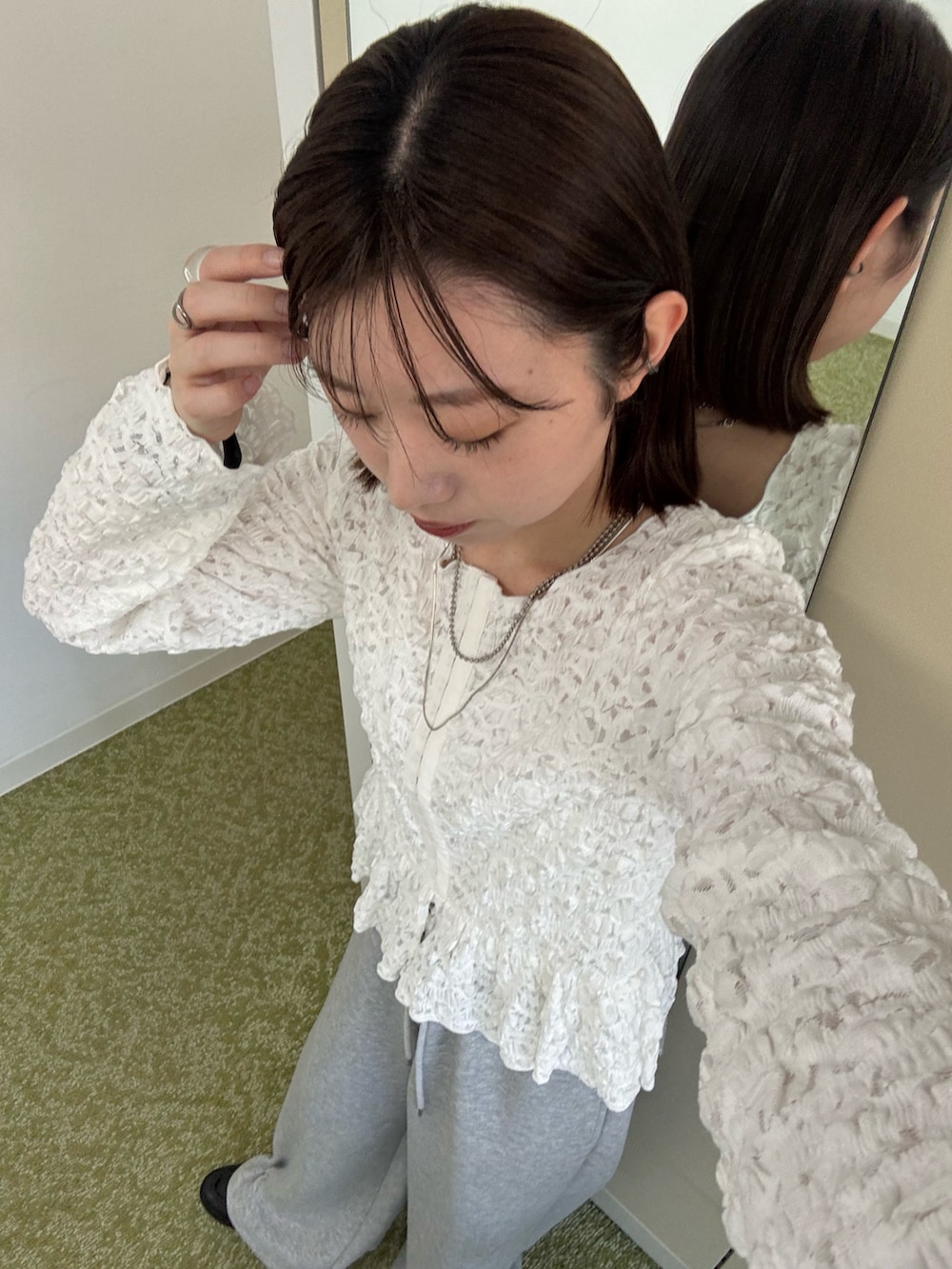 ホワイト系のトレンチコート、ホワイト系のシャツ/ブラウス、グレー系のスウェットパンツを着用したレディースの冬コーディネートの5枚目の写真