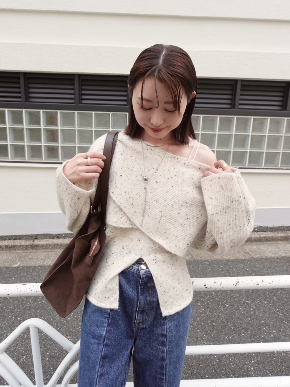 ホワイト系のニット/セーター、ブルー系のデニムパンツ、ブラウン系のトートバッグを着用したレディースの秋コーディネートの3枚目の写真