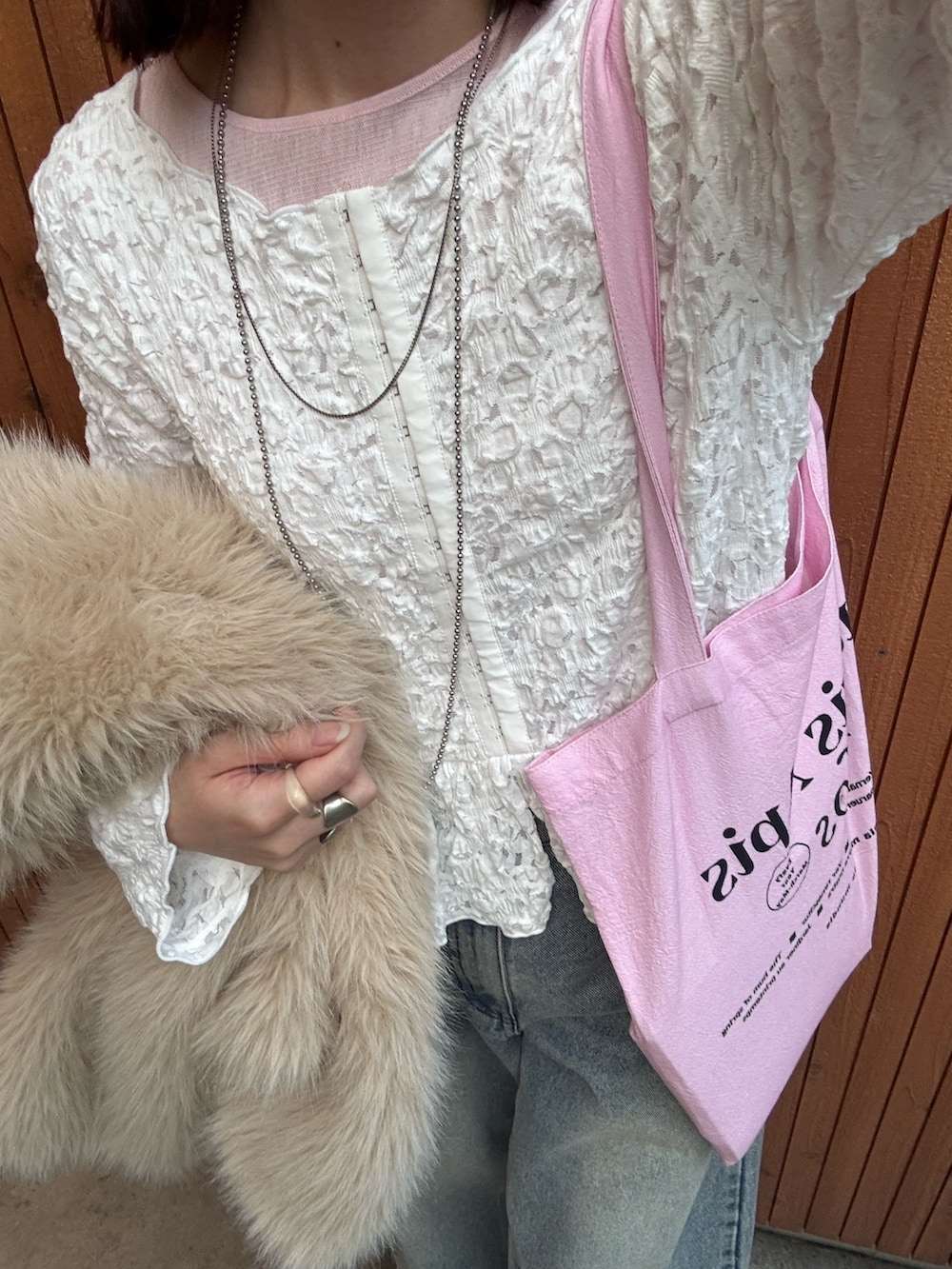 ベージュ系のその他アウター、ピンク系のトートバッグ、ブルー系のデニムパンツを着用したレディースの冬コーディネートの7枚目の写真