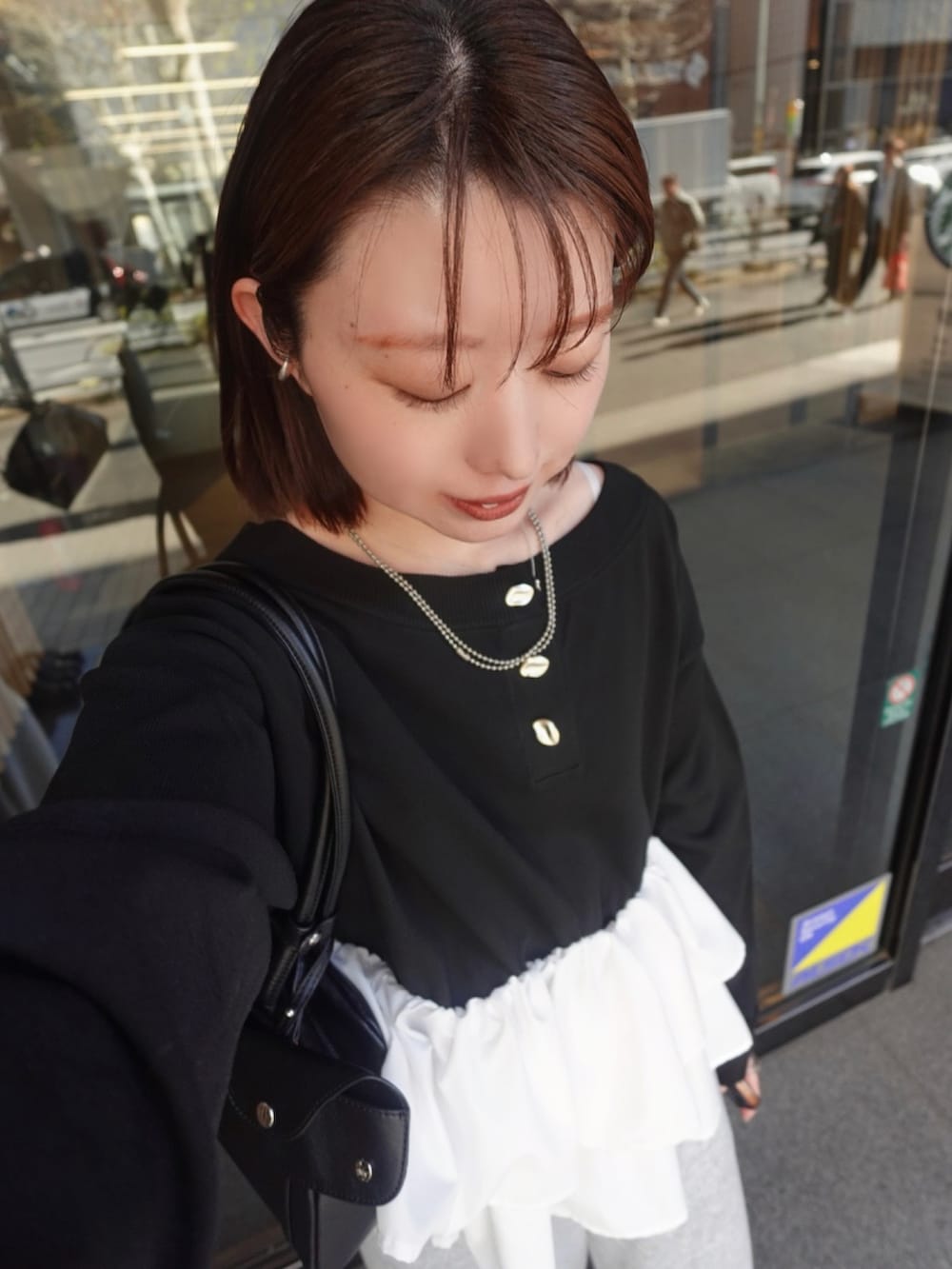 ブラック系のニット/セーター、グレー系のスウェットパンツを着用したレディースの冬コーディネートの2枚目の写真