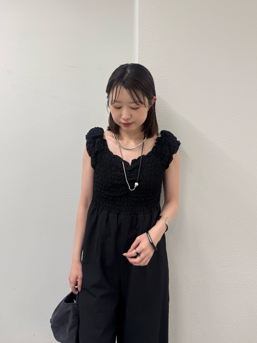 ブラック系のつなぎ/オールインワン、ブラック系のサンダル、ブラック系のキャップを着用したレディースの春コーディネートの2枚目の写真