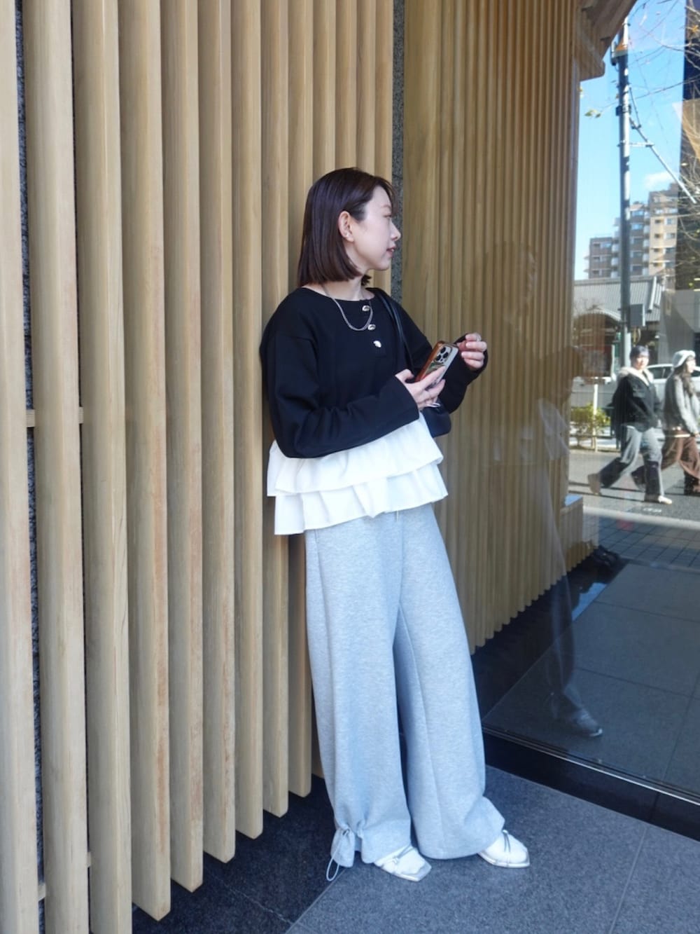 ブラック系のニット/セーター、グレー系のスウェットパンツを着用したレディースの冬コーディネートの3枚目の写真