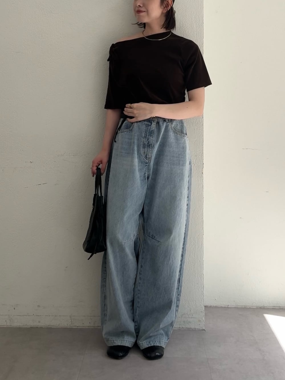 ブラウン系のTシャツ/カットソー、ブルー系のデニムパンツ、ブラック系のショルダーバッグを着用したレディースの夏コーディネートの2枚目の写真