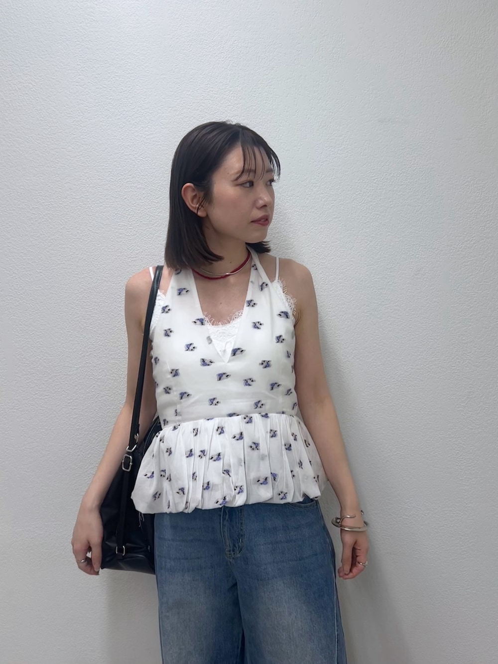 ブルー系のデニムパンツ、ホワイト系のシャツ/ブラウス、レッド系のネックレスを着用したレディースの春コーディネートの5枚目の写真