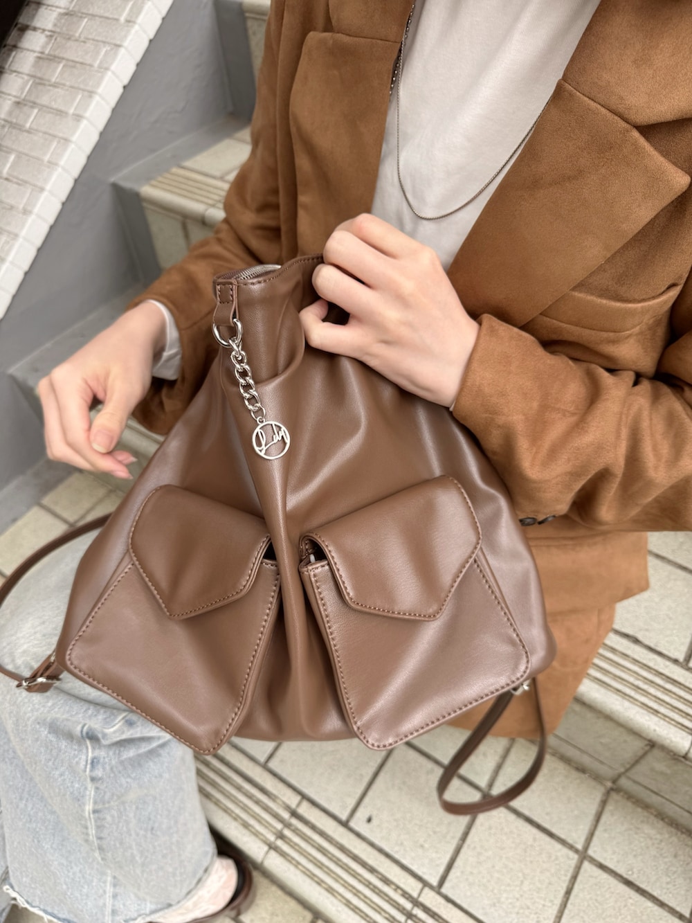 イエロー系のテーラードジャケット、イエロー系のトートバッグ、ブラウン系のブーツを着用したレディースの秋コーディネートの4枚目の写真