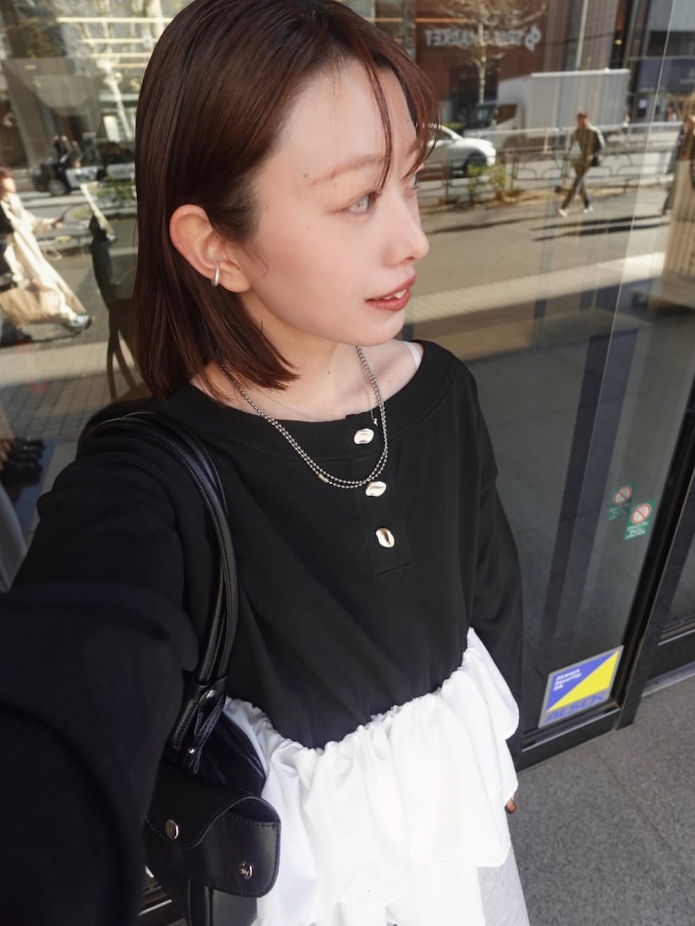 ブラック系のニット/セーター、グレー系のスウェットパンツを着用したレディースの冬コーディネートの4枚目の写真