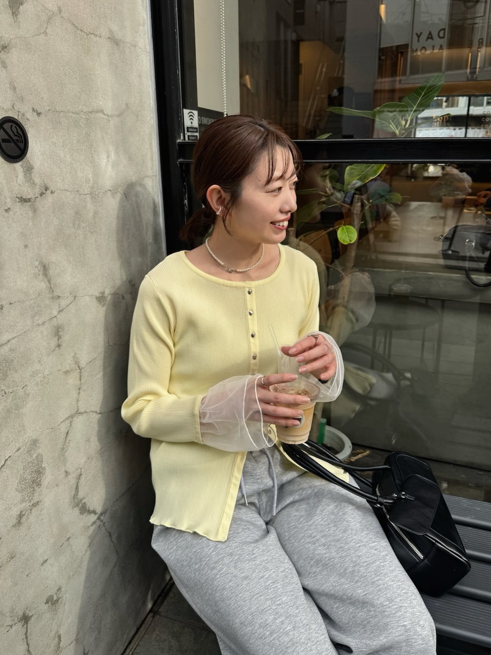 イエロー系のカーディガン/ボレロ、グレー系のスウェットパンツを着用したレディースの冬コーディネートの2枚目の写真