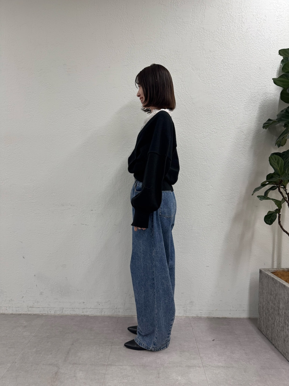 ブラック系のニット/セーター、ブルー系のデニムパンツを着用したレディースの秋コーディネートの2枚目の写真