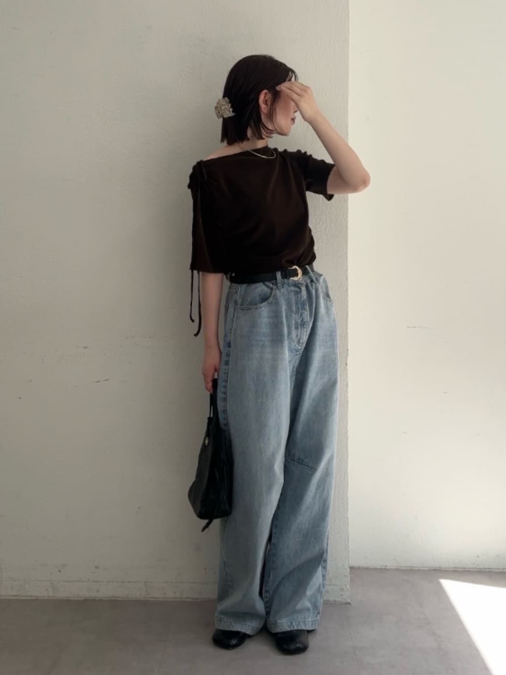 ブラウン系のTシャツ/カットソー、ブルー系のデニムパンツ、ブラック系のショルダーバッグを着用したレディースの夏コーディネートの3枚目の写真