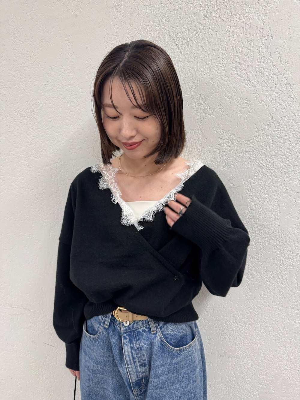 ブラック系のニット/セーター、ブルー系のデニムパンツを着用したレディースの秋コーディネートの5枚目の写真