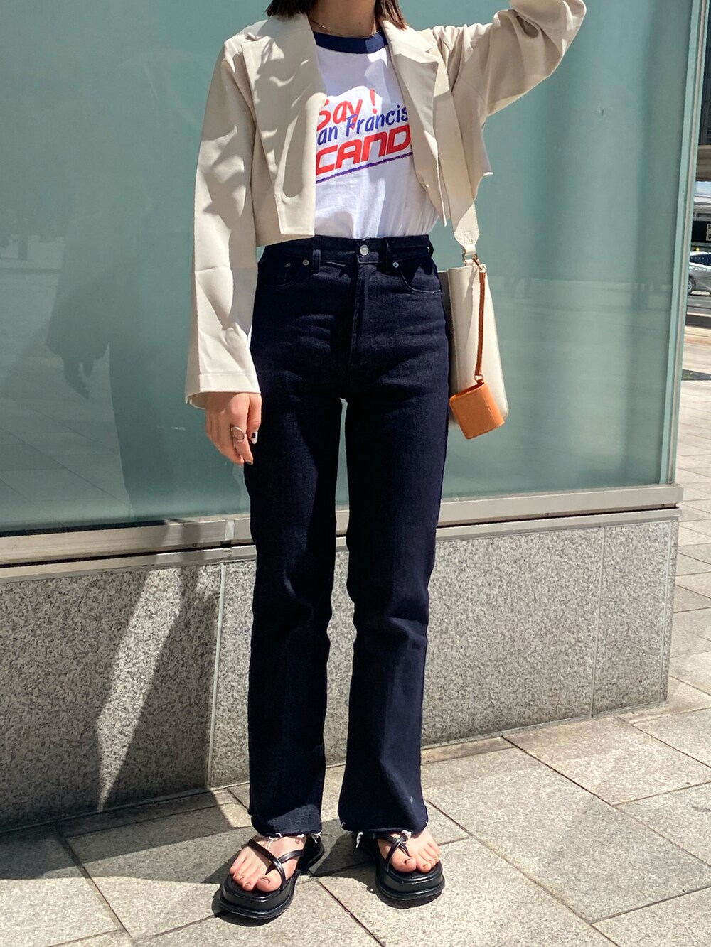 ホワイト系のTシャツ/カットソー、ホワイト系のテーラードジャケット、ブルー系のデニムパンツを着用したレディースの春コーディネートの2枚目の写真