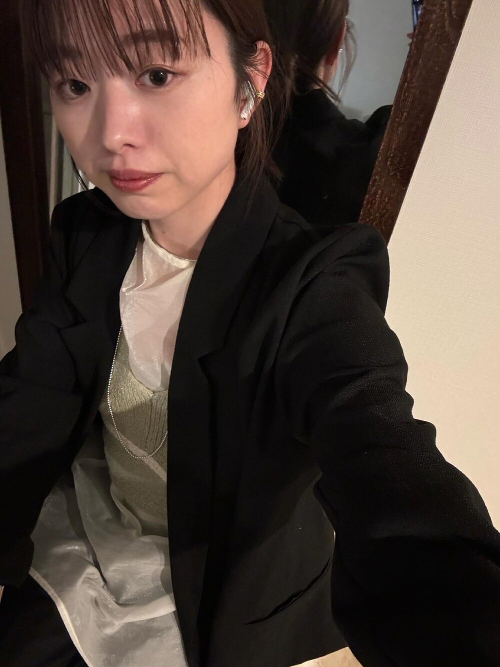 ブラック系のテーラードジャケット、グリーン系のシャツ/ブラウス、ホワイト系のスカートを着用したレディースの冬コーディネートの2枚目の写真