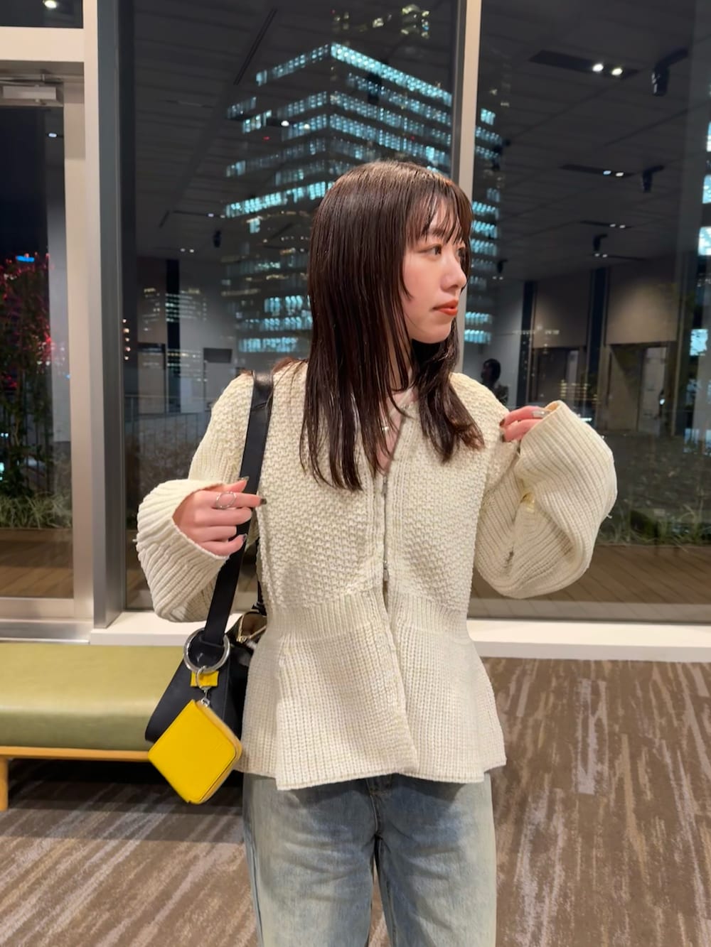 ブルー系のデニムパンツ、ホワイト系のカーディガン/ボレロを着用したレディースの冬コーディネートの2枚目の写真