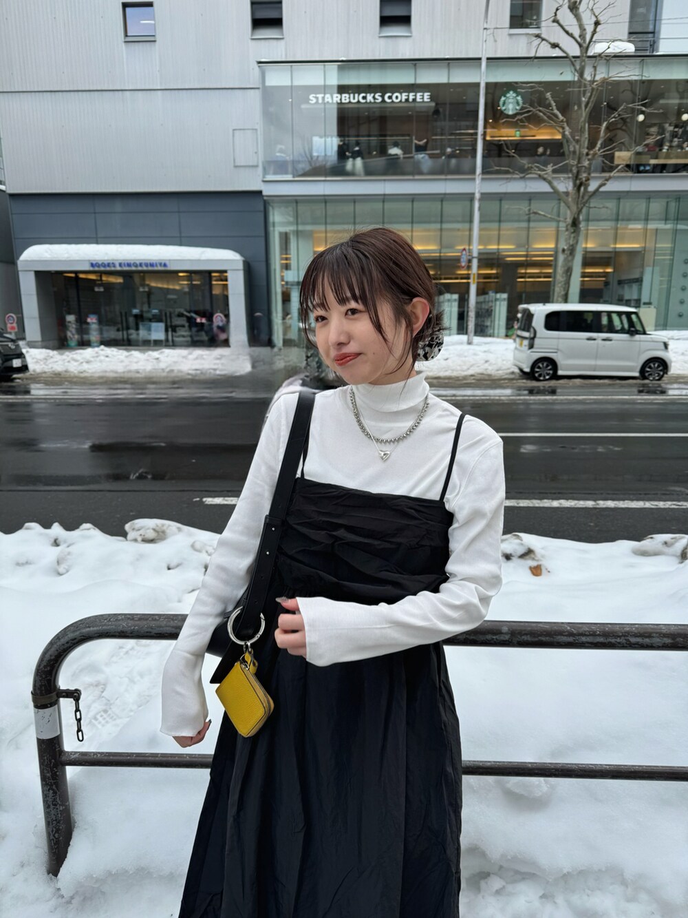 ブラック系のワンピース、ブラック系のブーツ、ブラック系のショルダーバッグを着用したレディースの冬コーディネートの2枚目の写真