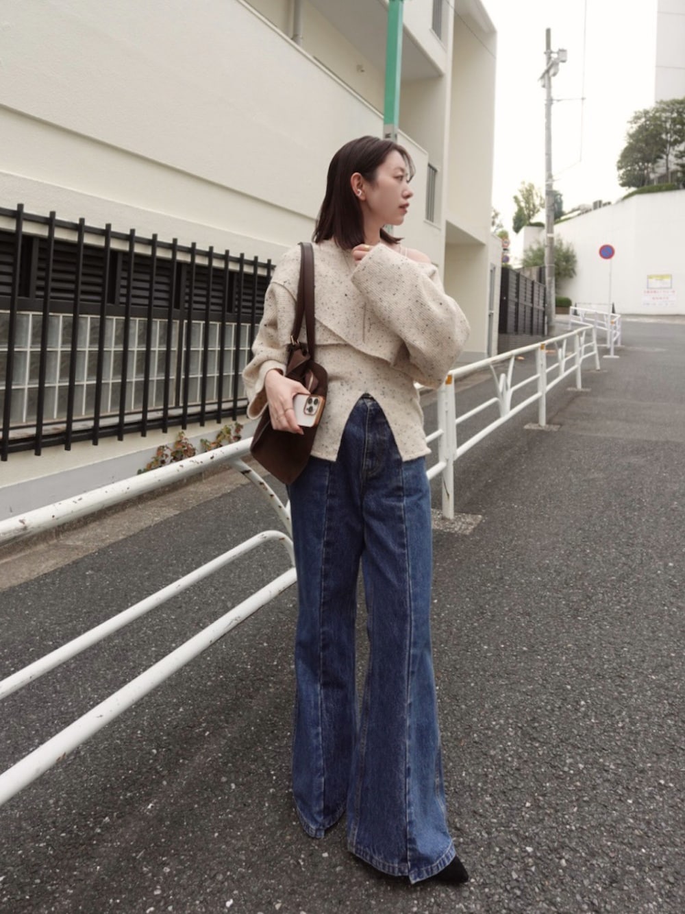 ホワイト系のニット/セーター、ブルー系のデニムパンツ、ブラウン系のトートバッグを着用したレディースの秋コーディネートの5枚目の写真
