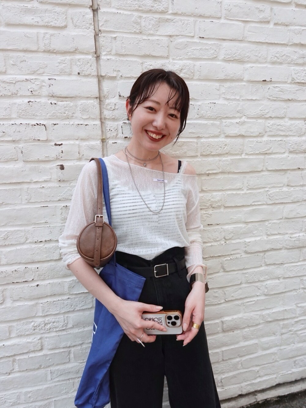 ホワイト系のTシャツ/カットソー、ブラック系のデニムパンツ、ホワイト系のキャミソールを着用したレディースの夏コーディネートの4枚目の写真