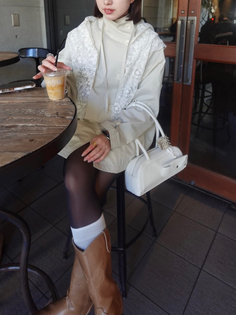 ホワイト系のトレンチコート、イエロー系のブーツを着用したレディースの冬コーディネートの6枚目の写真