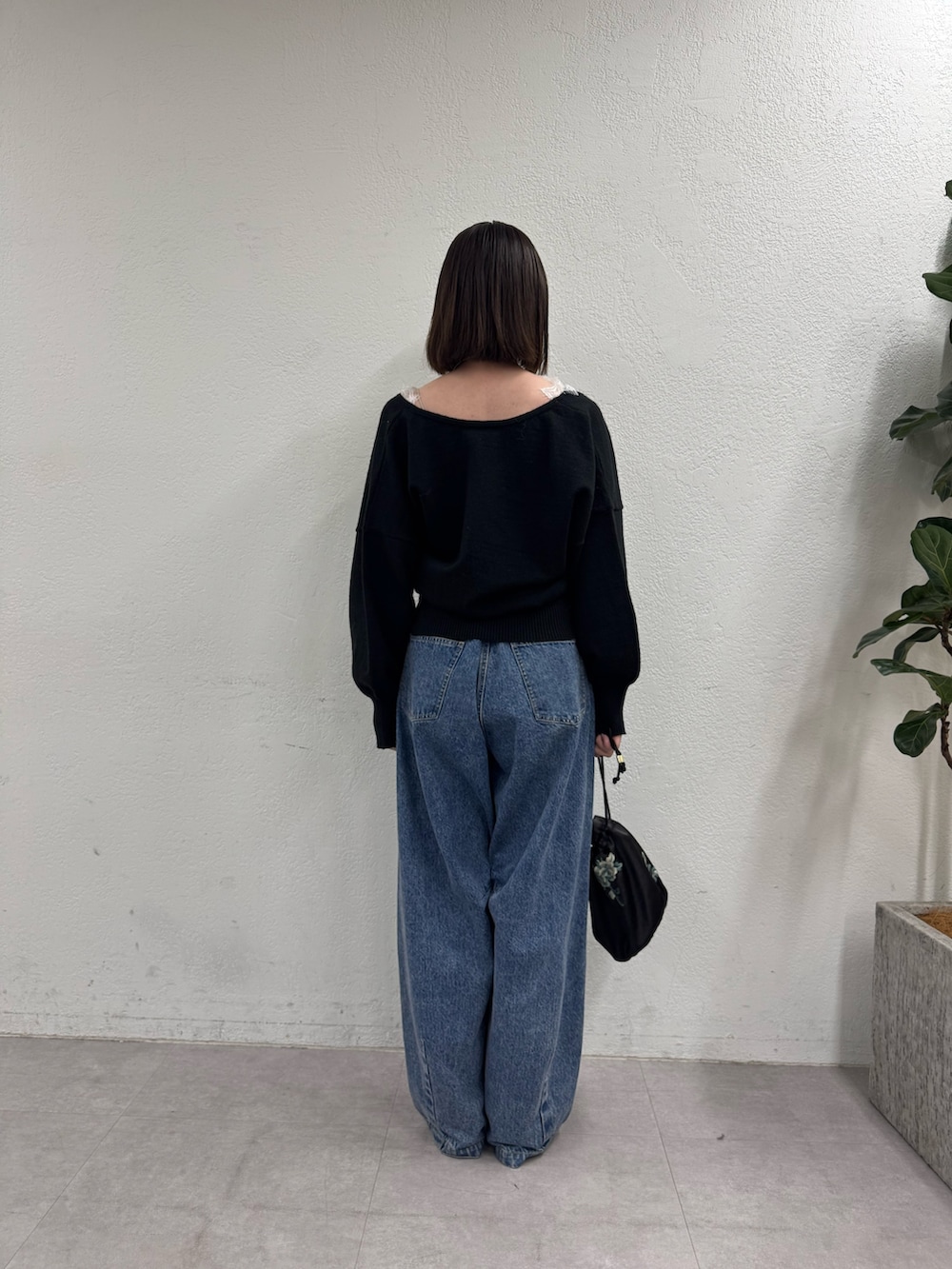 ブラック系のニット/セーター、ブルー系のデニムパンツを着用したレディースの秋コーディネートの3枚目の写真