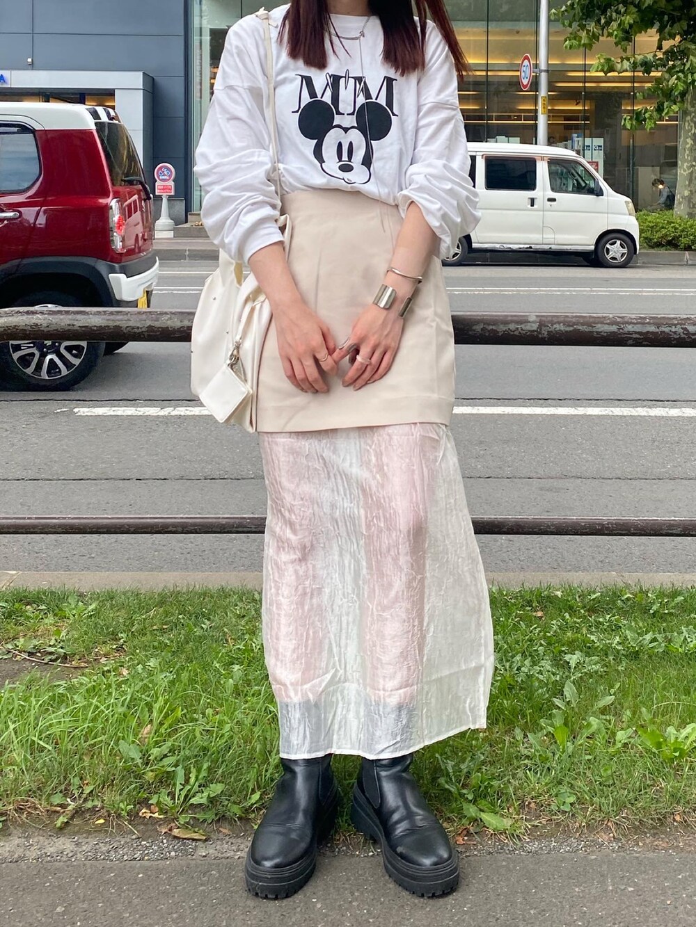 ホワイト系のTシャツ/カットソー、ホワイト系のスカート、ブラック系のブーツを着用したレディースの夏コーディネートの2枚目の写真