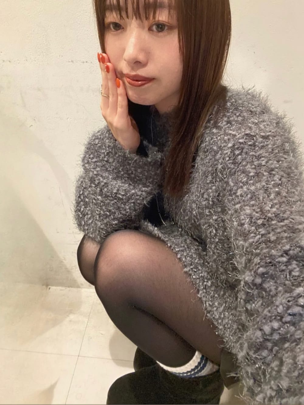 グレー系のカーディガン/ボレロ、ブラック系のスカートを着用したレディースの秋コーディネートの5枚目の写真